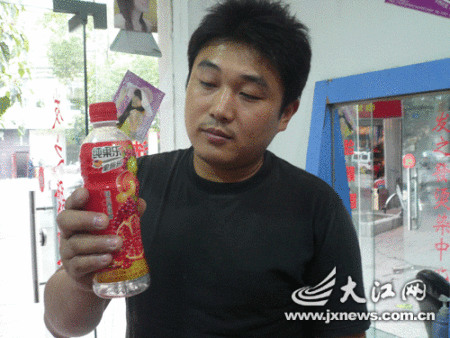王先生拿著女兒喝過的“問題”飲料。 王先生拿著女兒喝過的“問題”飲料。
