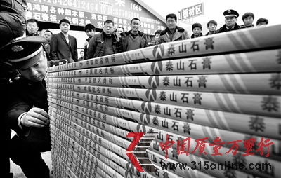 圖為工商執(zhí)法人員清點(diǎn)假冒石膏板